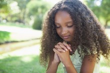 Young Girl Praying In The Park