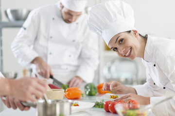 Wall Mural -  female chef preparing a dish in a professional kitchen