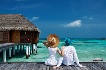 Canvas Print - Couple on a beach jetty at Maldives