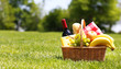 Picnic basket with food on green grass