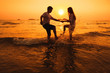 © Song_about_summer - couple having fun in the sea at sunset beach