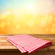 © maglara - Empty wooden deck table with tablecloth sunset bokeh background