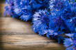 Cornflowers over wooden background. Wild blue flowers
