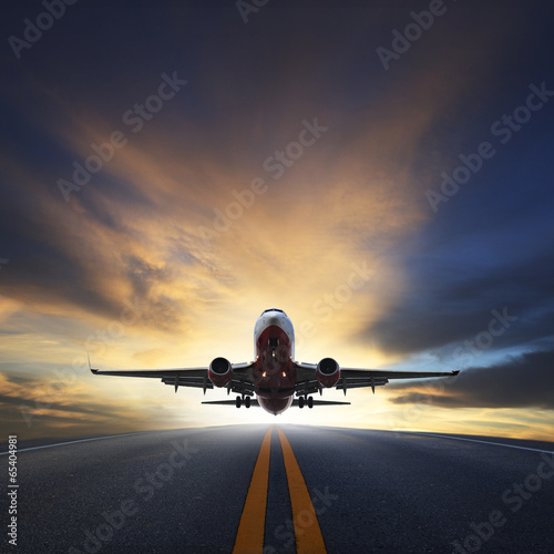 Naklejka ścienna passenger plane take off from runways against beautiful dusky sk