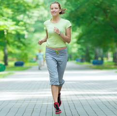 Wall Mural - Woman jogging in city street park.