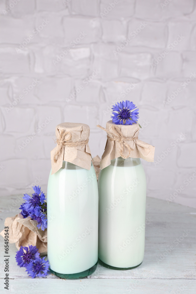 Bottles of milk and cornflowers on wooden table