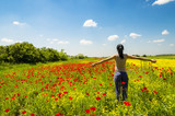 Fototapeta Kuchnia - Young woman relaxing in a poppy field