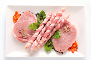 Raw fresh meat on board with condiments on white background