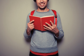 Happy young student with red book