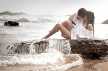 Young Beautiful Couple Kissing On Beach Rocks