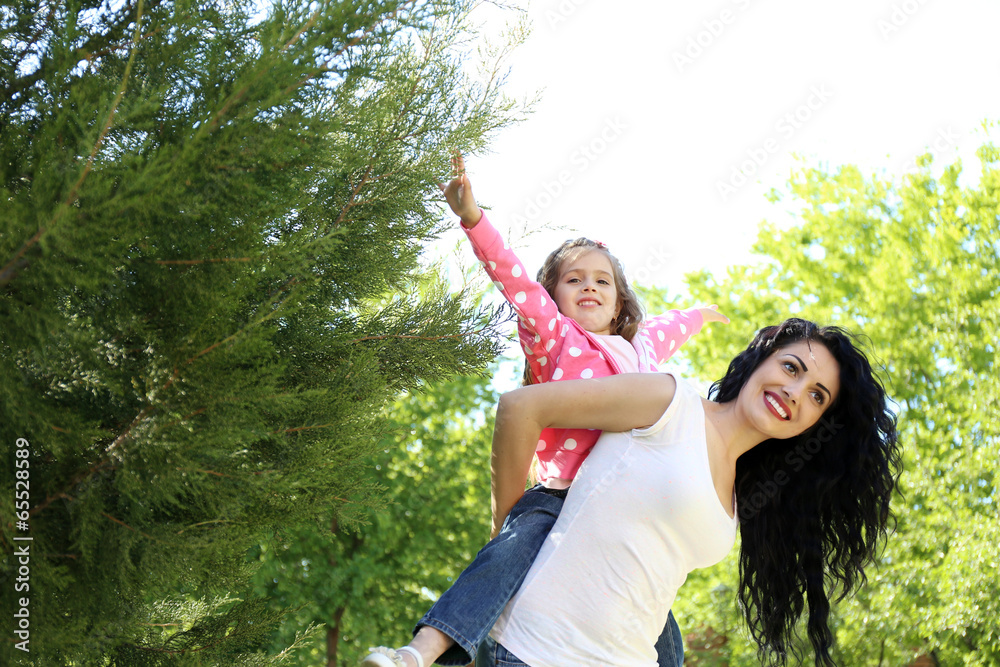 Happy mom and daughter. Walk in the green park