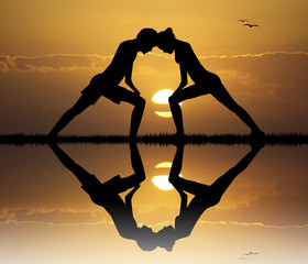 Wall Mural - couple doing yoga at sunset