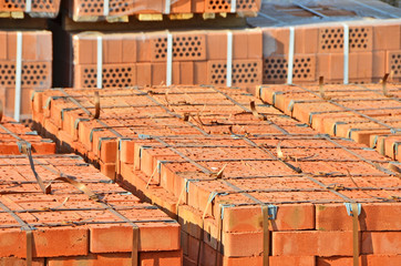 Stack of orange clay silicate brick on construction site