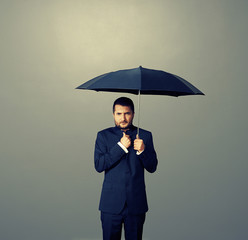 Wall Mural - man under black umbrella over dark