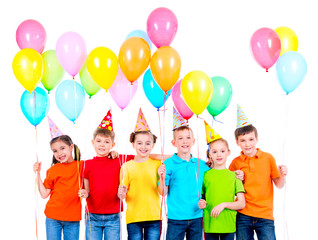 Group of children in colored t-shirts and party hats.