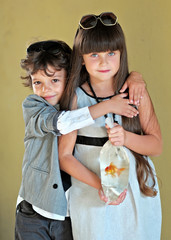 Wall Mural - Portrait of a girl and boy with a goldfish