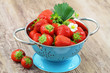Fresh strawberries in blue colander