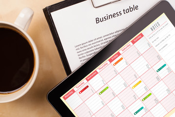 Wall Mural - tablet pc showing calendar on screen with a cup of coffee on a d