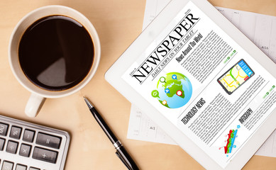 Wall Mural - tablet pc shows news on screen with a cup of coffee on a desk