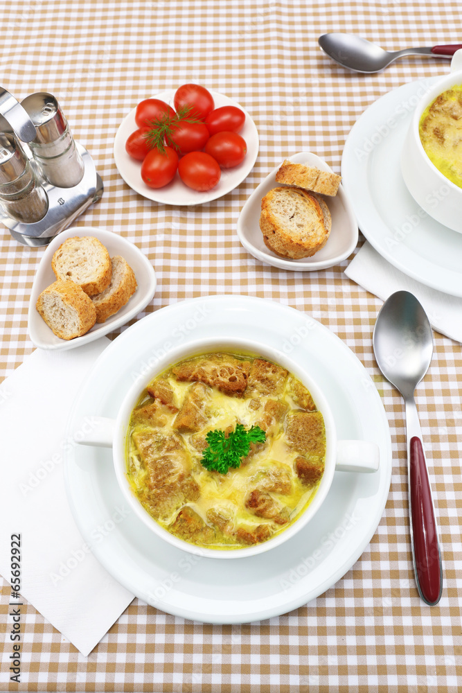 Tasty soup in saucepan on tablecloth, close up