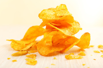 Heap of homemade potato chips on light background