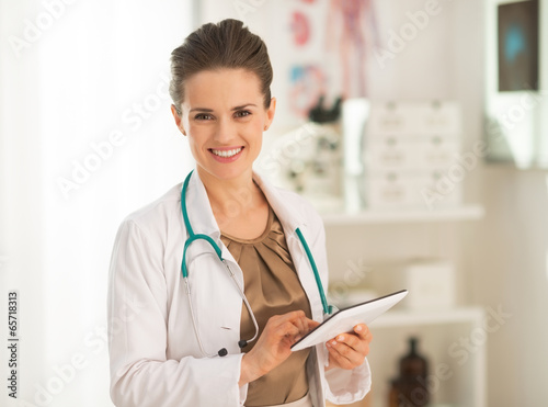 Fotografía Smiling medical doctor woman using tablet pc