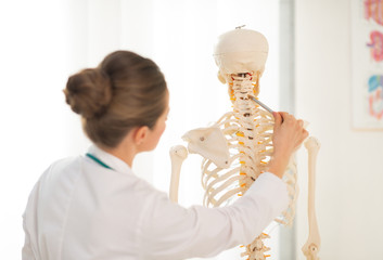 Wall Mural - Medical doctor woman teaching anatomy using human skeleton model