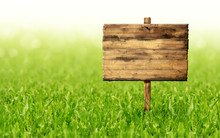 Wooden Sign On A Green Grass Lawn