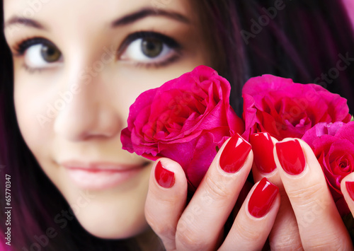 Red manicure on a woman hands with red roses. Poster