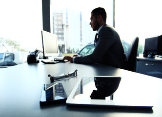 Silhouette of businessman using laptop in office 