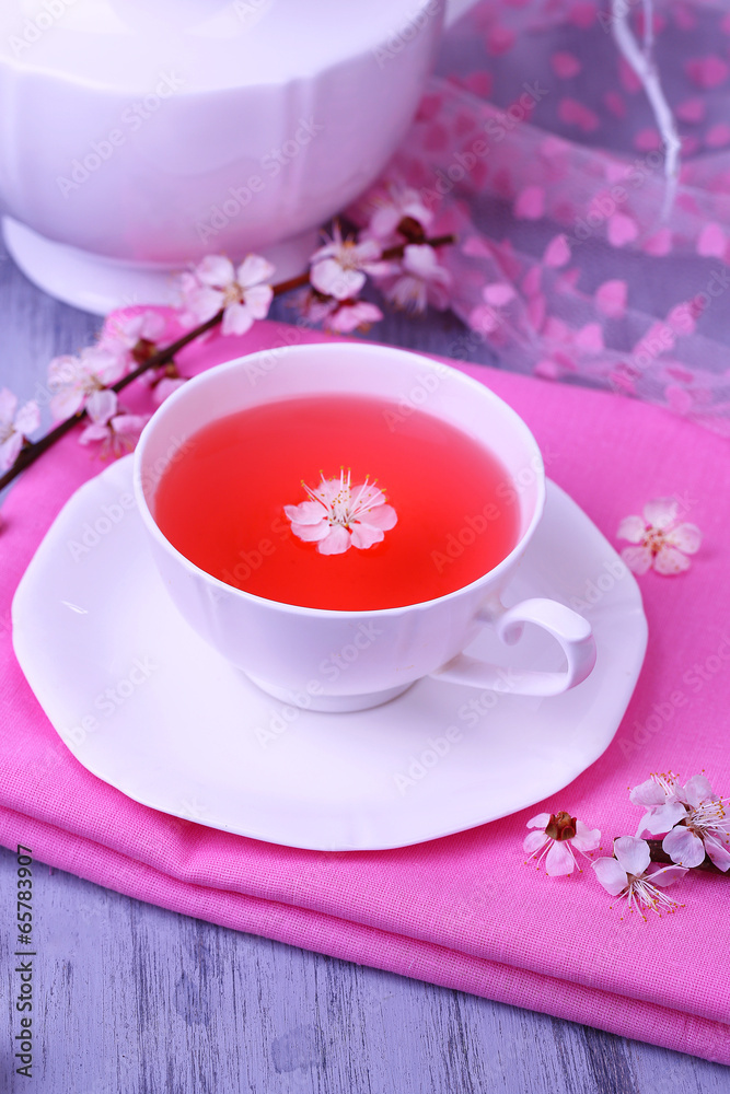 Fragrant tea with flowering branches on wooden table close-up