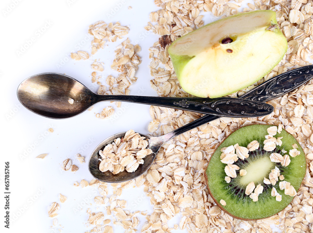 Apple, kiwi fruit with oatmeal and vintage spoon isolated
