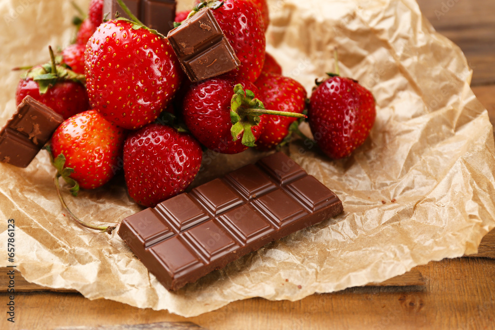 Red ripe strawberries with chocolate on wooden table
