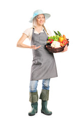 Canvas Print - Woman holding a basket full of vegetables