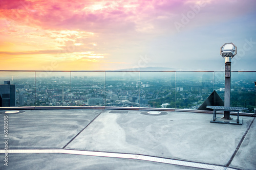 Nowoczesny obraz na płótnie hand held binoculars or telescope on top of skyscraper