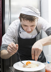 Wall Mural - chef preparing food in the kitchen at the restaurant