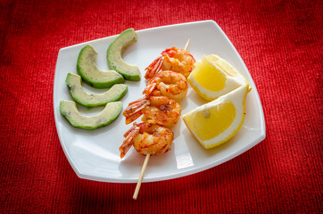 Shrimps skewers with avocado and lemon slices