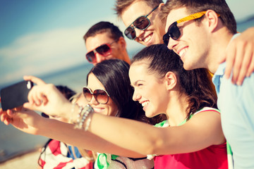 Wall Mural - group of friends taking picture with smartphone