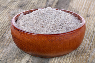 whole grain flour in a bowl on a rustic table