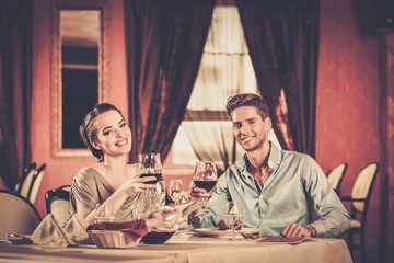 Wall Mural - Young couple with glasses of wine in restaurant