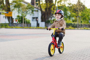 Wall Mural - Little toddler boy having fun and riding his bike