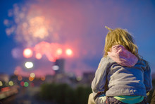 Rear View Of Little Girl Against A Beautiful Fireworks