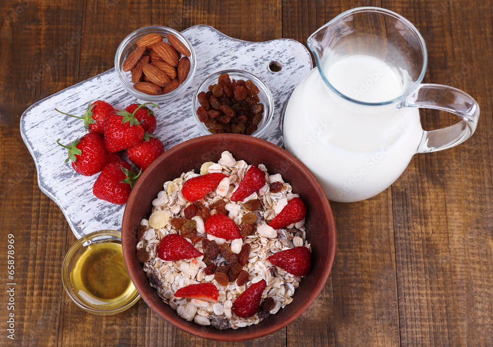 Healthy cereal with milk and strawberry on wooden table