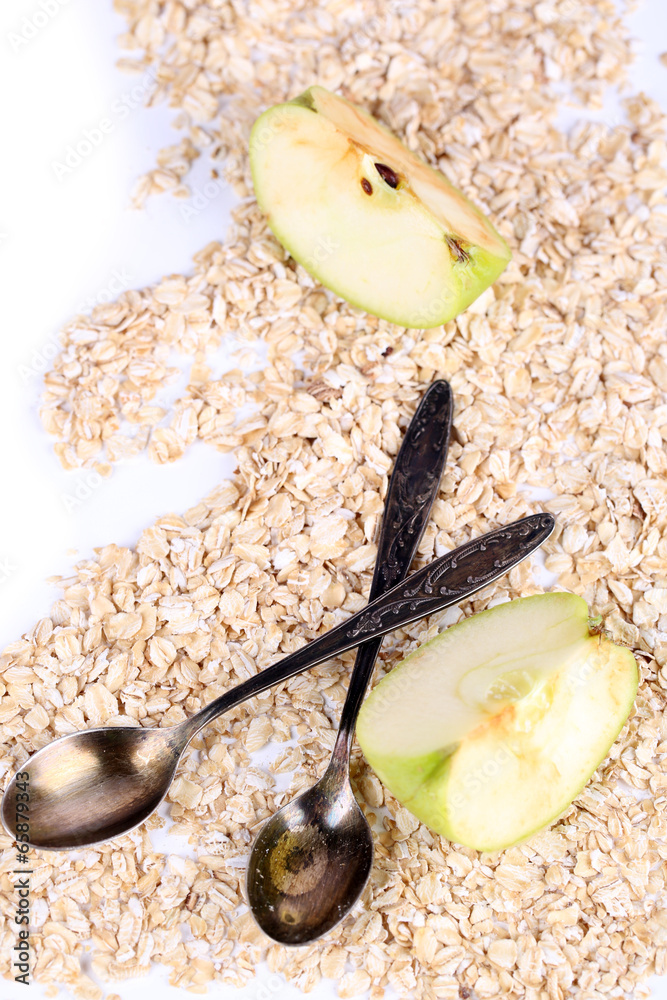 Apple with oatmeal and vintage spoons, isolated on white