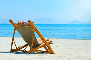 Sticker - Woman relaxing on a beautiful white beach.