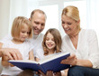 © Syda Productions - smiling family and two little girls with book