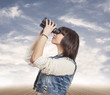 © asierromero - curious young woman looking through the binoculars