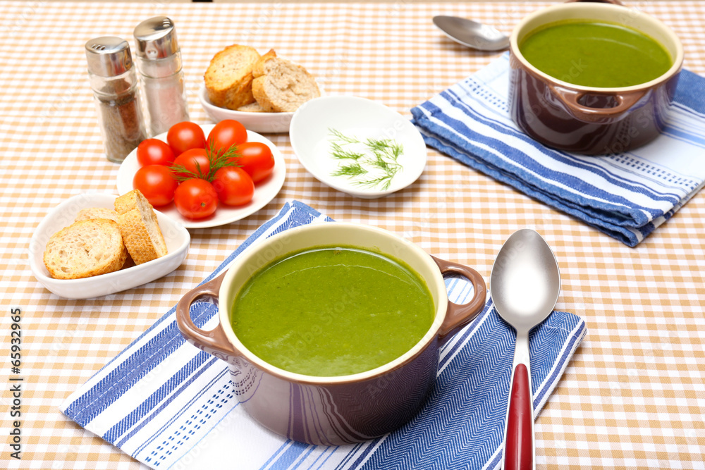 Tasty soup in saucepans on tablecloth, close up