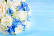 Beautiful wedding bouquet with roses on blue wooden table