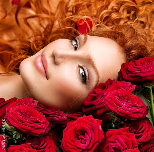 Fototapeta na wymiar Woman with permed red hair and beautiful red roses